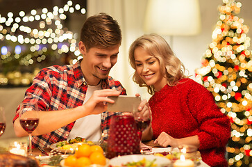 Image showing couple with smartphone at home christmas dinner