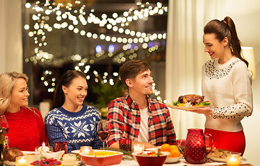 Image showing happy friends having christmas dinner at home