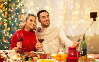 Image showing couple taking picture by selfie stick at christmas