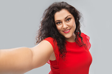 Image showing happy woman in red dress taking selfie