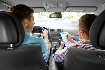 Image showing car driving instructor with clipboard and driver