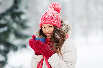 Image showing happy young woman with tea cup in winter park