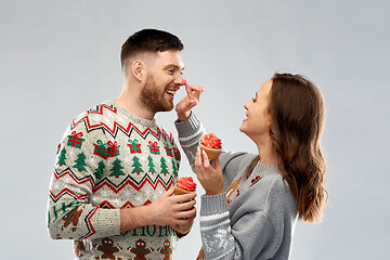 Image showing couple with cupcakes in ugly christmas sweaters