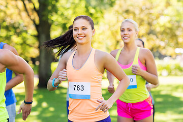 Image showing happy young sportsmen racing wit badge numbers