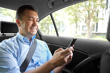 Image showing passenger or businessman using smartphone in car