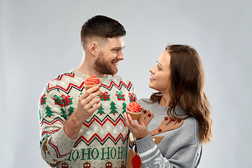 Image showing couple with cupcakes in ugly christmas sweaters