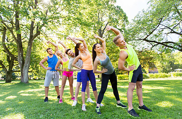 Image showing group of happy people exercising at summer park