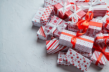 Image showing A pile various size wrapped in festive paper boxed gifts placed on stack. Christmas concept