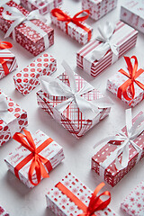 Image showing Colorful white and red Christmas theme. Wrapped gifts in festive paper with ribbon