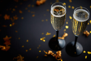 Image showing Two glasses full of sparkling champagne wine with golden decoration