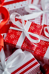 Image showing Christmas concept. Close up on festive paper wrapped gifts with ribbon