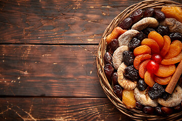 Image showing Mix of dried fruits in a small wicker basket on wooden table