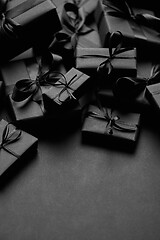 Image showing A pile various size black boxed gifts placed on stack. Christmas concept.