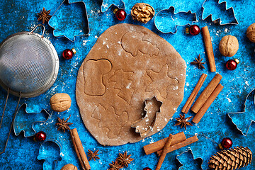 Image showing Christmas baking concept. Gingerbread dough with different cutter shapes