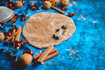 Image showing Christmas baking concept. Gingerbread dough with different cutter shapes