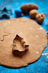 Image showing Christmas baking concept. Gingerbread dough with different cutter shapes