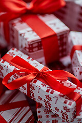 Image showing Christmas concept. Close up on festive paper wrapped gifts with ribbon