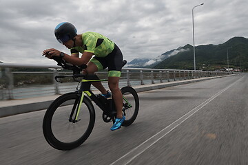 Image showing triathlon athlete riding a bike on morning training