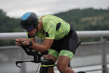 Image showing triathlon athlete riding a bike on morning training