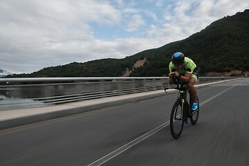 Image showing triathlon athlete riding a bike on morning training