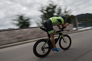 Image showing triathlon athlete riding a bike on morning training