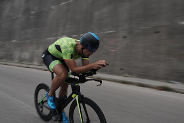 Image showing triathlon athlete riding a bike on morning training