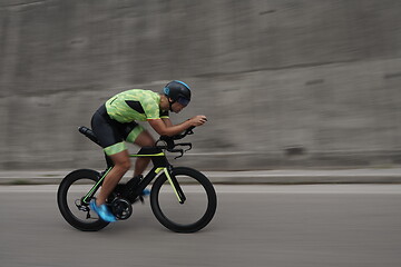 Image showing triathlon athlete riding a bike on morning training