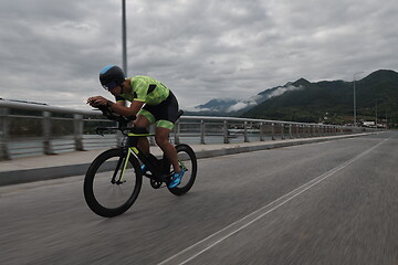 Image showing triathlon athlete riding a bike on morning training