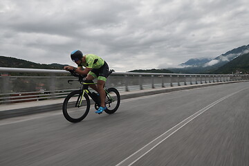 Image showing triathlon athlete riding a bike on morning training