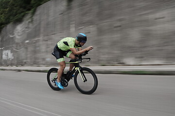 Image showing triathlon athlete riding a bike on morning training