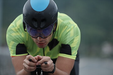 Image showing triathlon athlete riding a bike on morning training