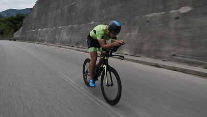 Image showing triathlon athlete riding a bike on morning training