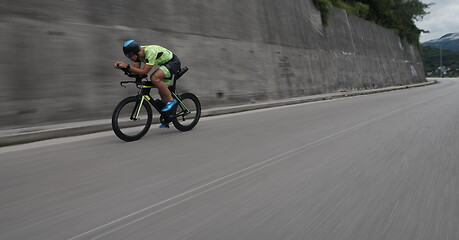 Image showing triathlon athlete riding a bike on morning training