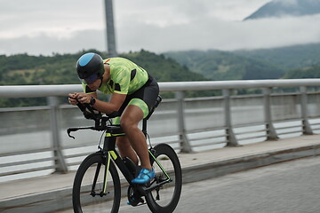 Image showing triathlon athlete riding a bike on morning training