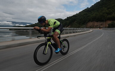 Image showing triathlon athlete riding a bike on morning training