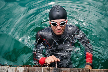 Image showing triathlete swimmer portrait wearing wetsuit on training