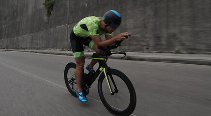 Image showing triathlon athlete riding a bike on morning training