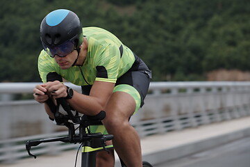 Image showing triathlon athlete riding a bike on morning training