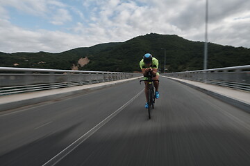 Image showing triathlon athlete riding a bike on morning training