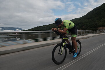 Image showing triathlon athlete riding a bike on morning training