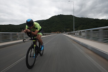 Image showing triathlon athlete riding a bike on morning training