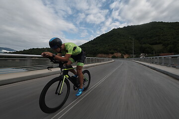 Image showing triathlon athlete riding a bike on morning training