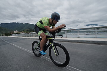 Image showing triathlon athlete riding a bike on morning training