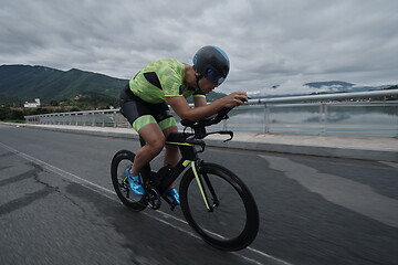 Image showing triathlon athlete riding a bike on morning training