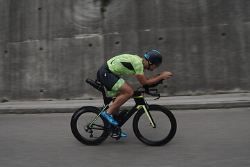 Image showing triathlon athlete riding a bike on morning training