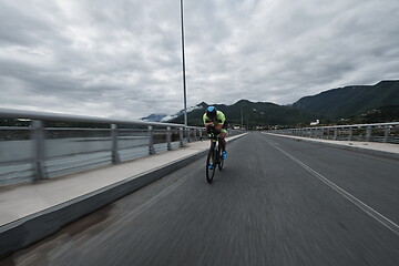 Image showing triathlon athlete riding a bike on morning training