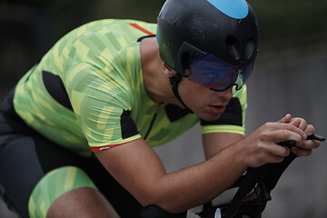 Image showing triathlon athlete riding a bike on morning training