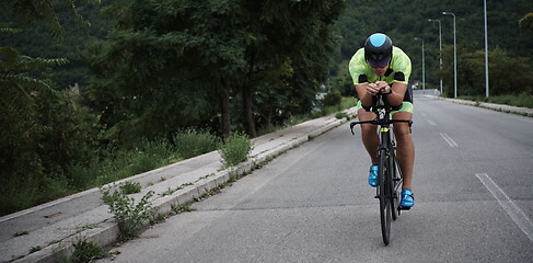 Image showing triathlon athlete riding a bike on morning training