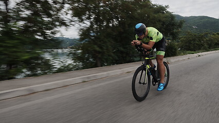 Image showing triathlon athlete riding a bike on morning training