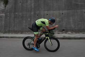 Image showing triathlon athlete riding a bike on morning training